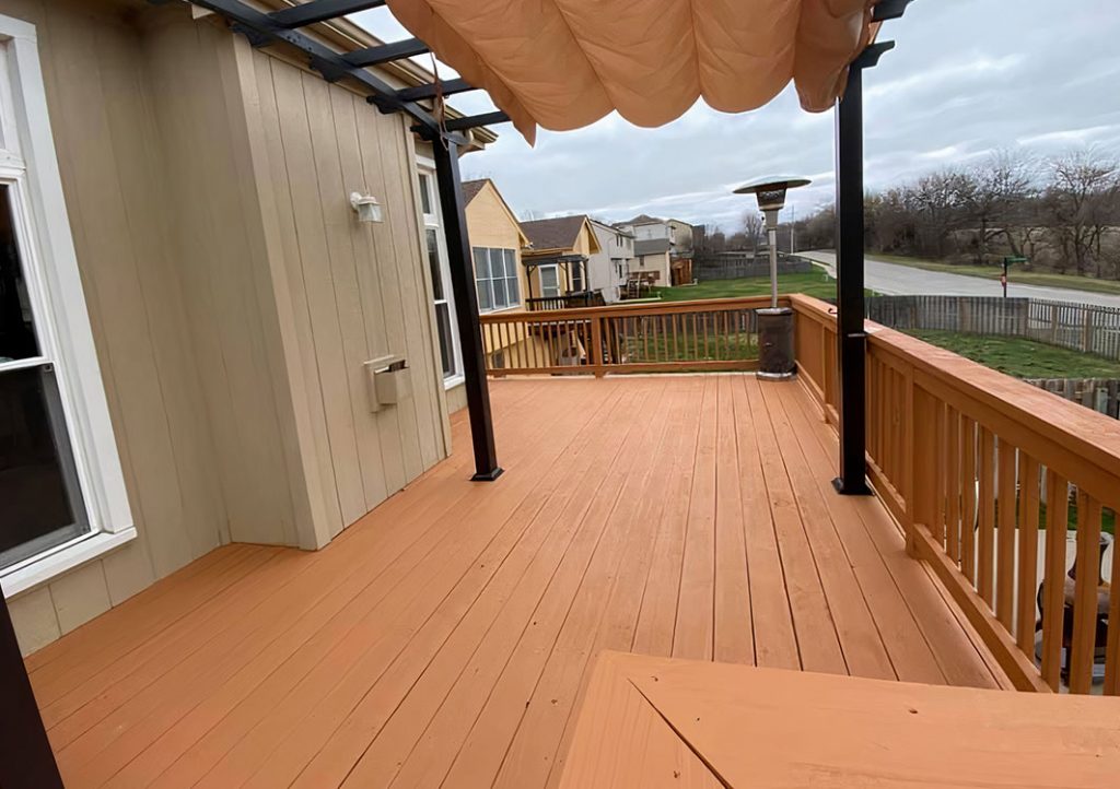 Newly built composite deck with textile cover and wooden railings.