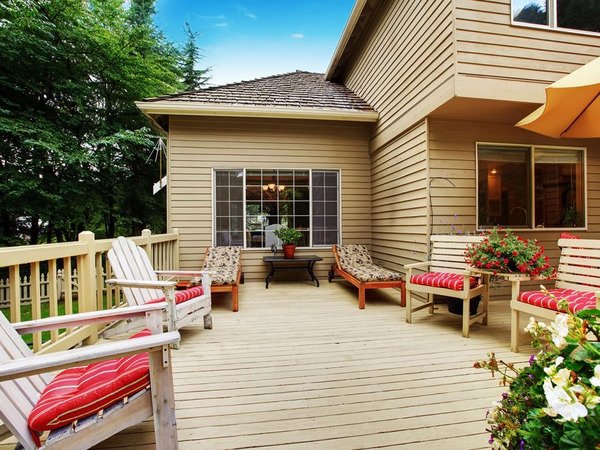 A wood deck with furniture and flowers