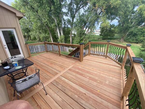 A wood deck with metal and wood railing