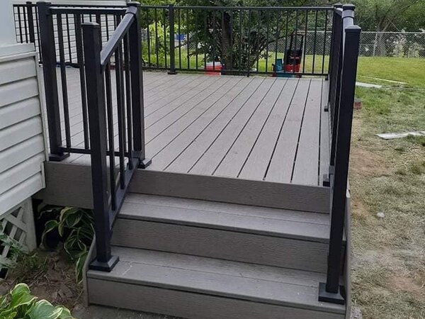 Slightly raised deck with gray flooring and black metal railing