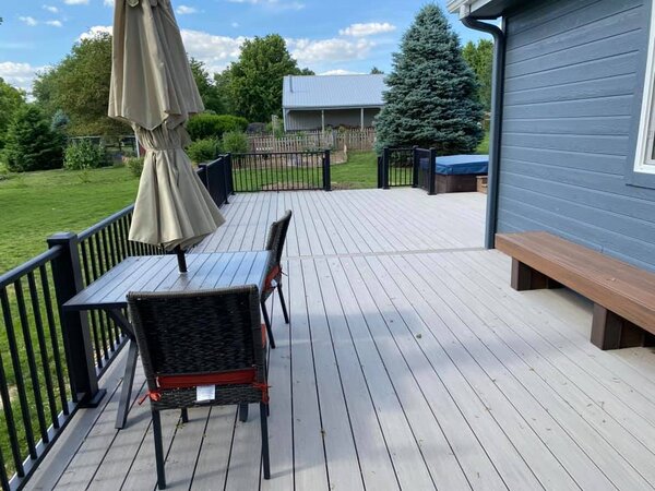 A composite deck with a glass table and chairs