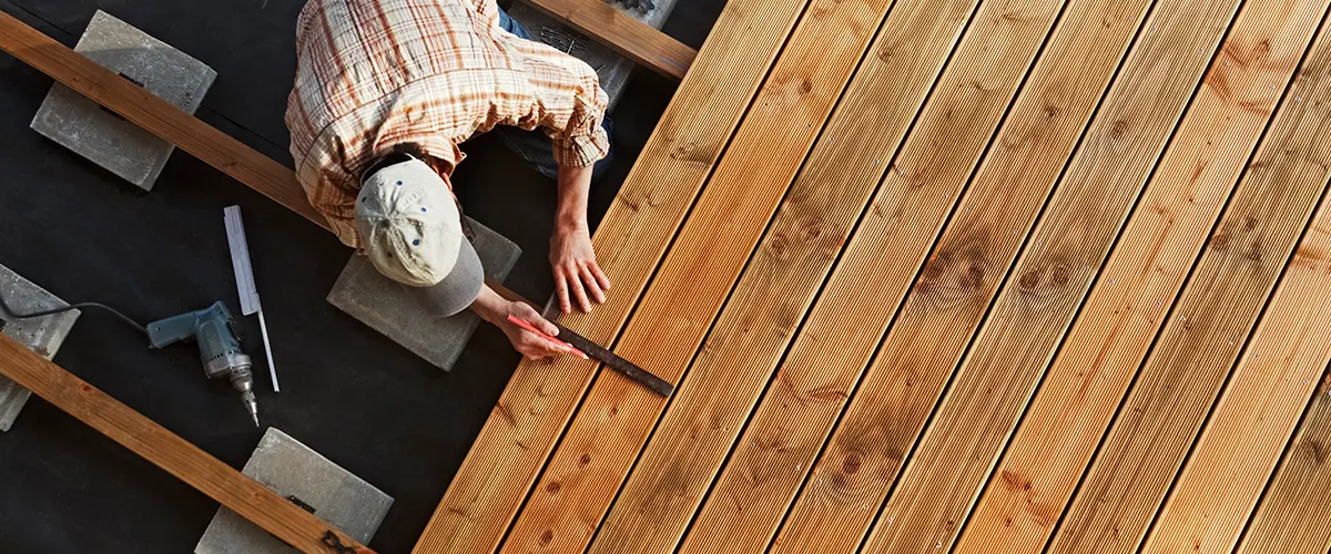 A man installing and leveling composite decking boards
