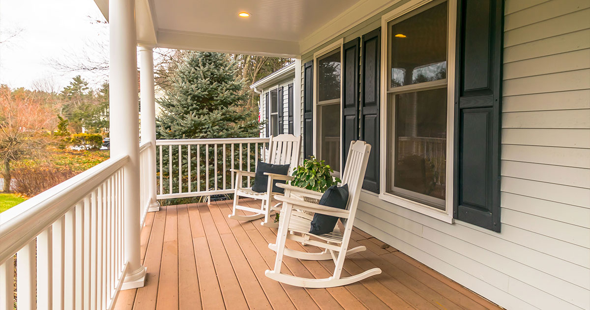 Two rocking chairs on a deck with white railings