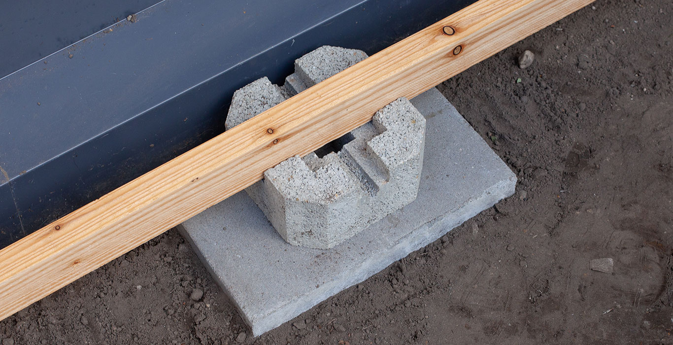 Deck block with concrete and a lumber piece