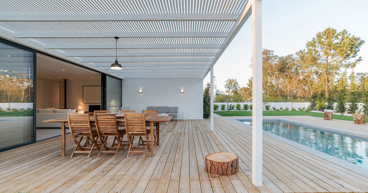 A deck with a white cover near a pool