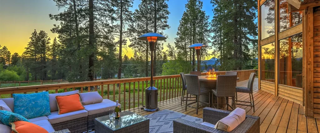 Bellevue vs. Gretna: Which Has the Most Lenient Deck Regulations? A lit fireplace with chairs and a table at dawn