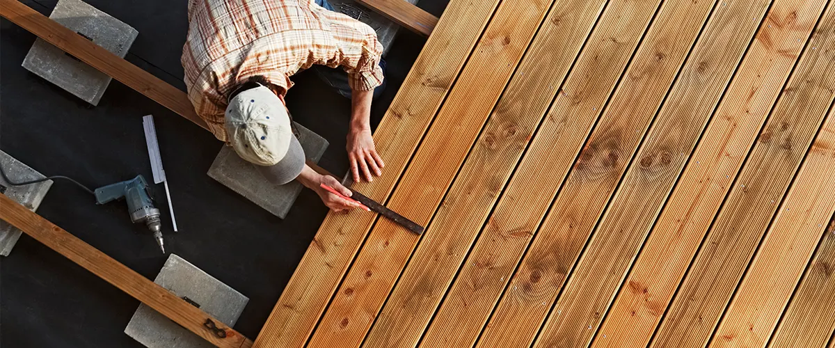 A man leveling and installing composite deck boards