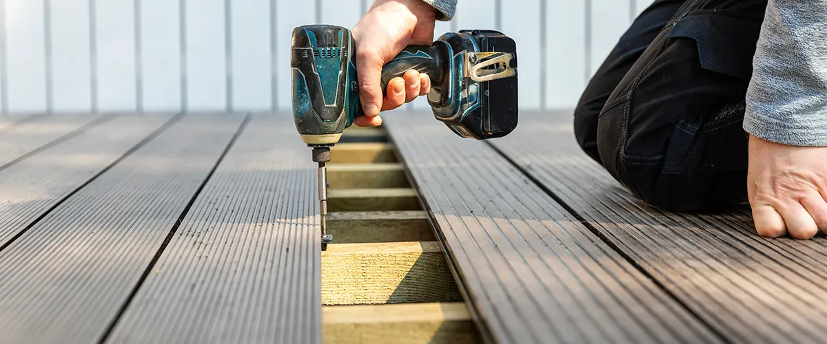 A man with screwdriver installing decking