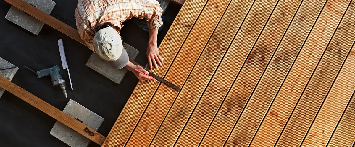 A man working on the best deck installation of composite deck boards