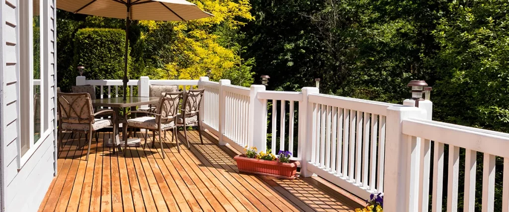 A wood deck with white wood railing