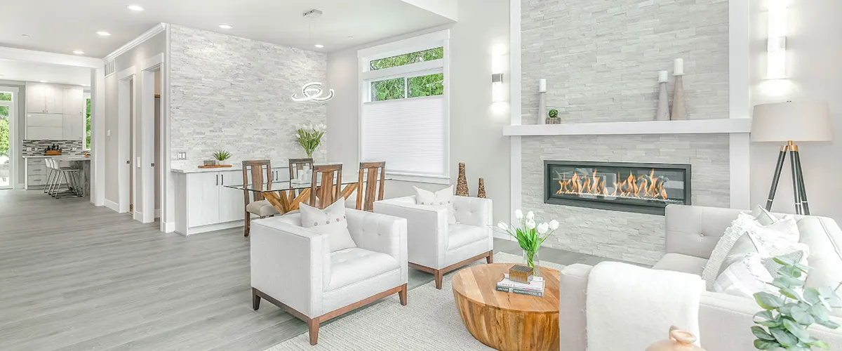 An elegant home with white chairs and a fireplace