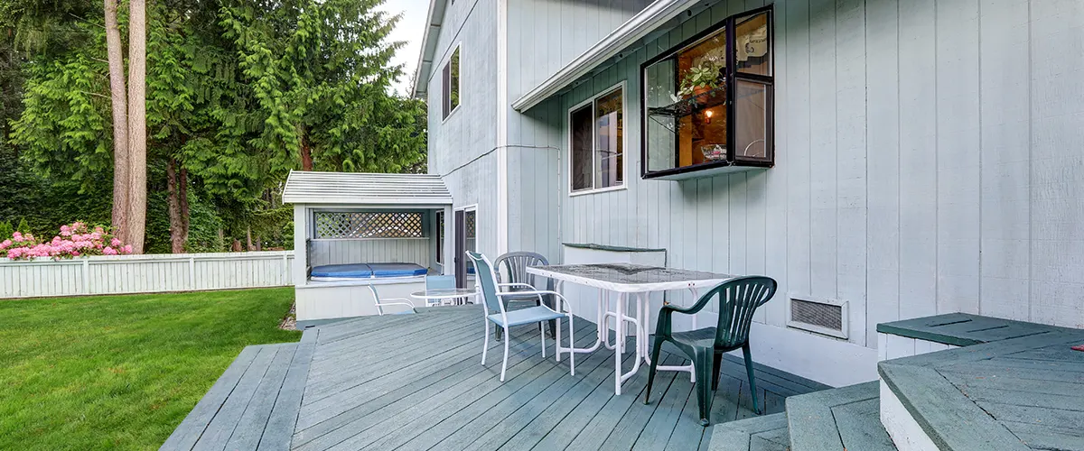 A composite deck with plastic chairs and table