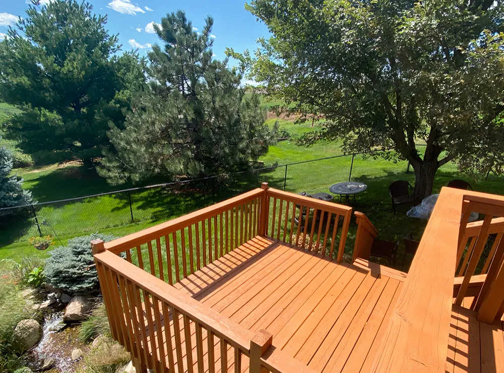 A wood deck with a wood railing after a deck repair project