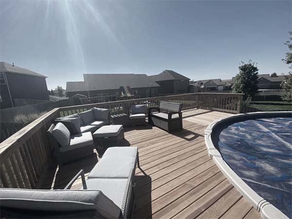 A pool deck with long chairs and a table