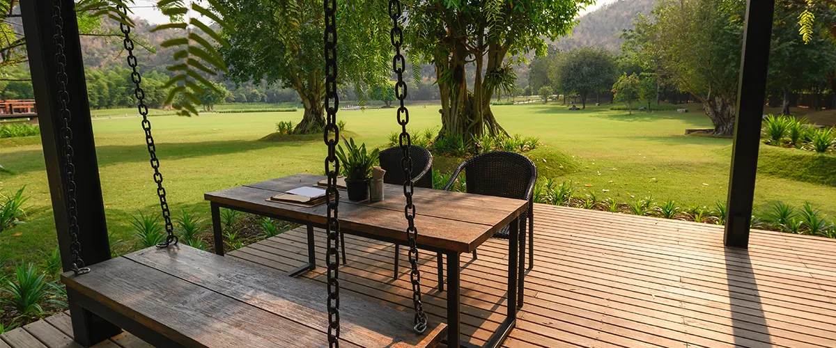A composite deck with a swinger and a wood table