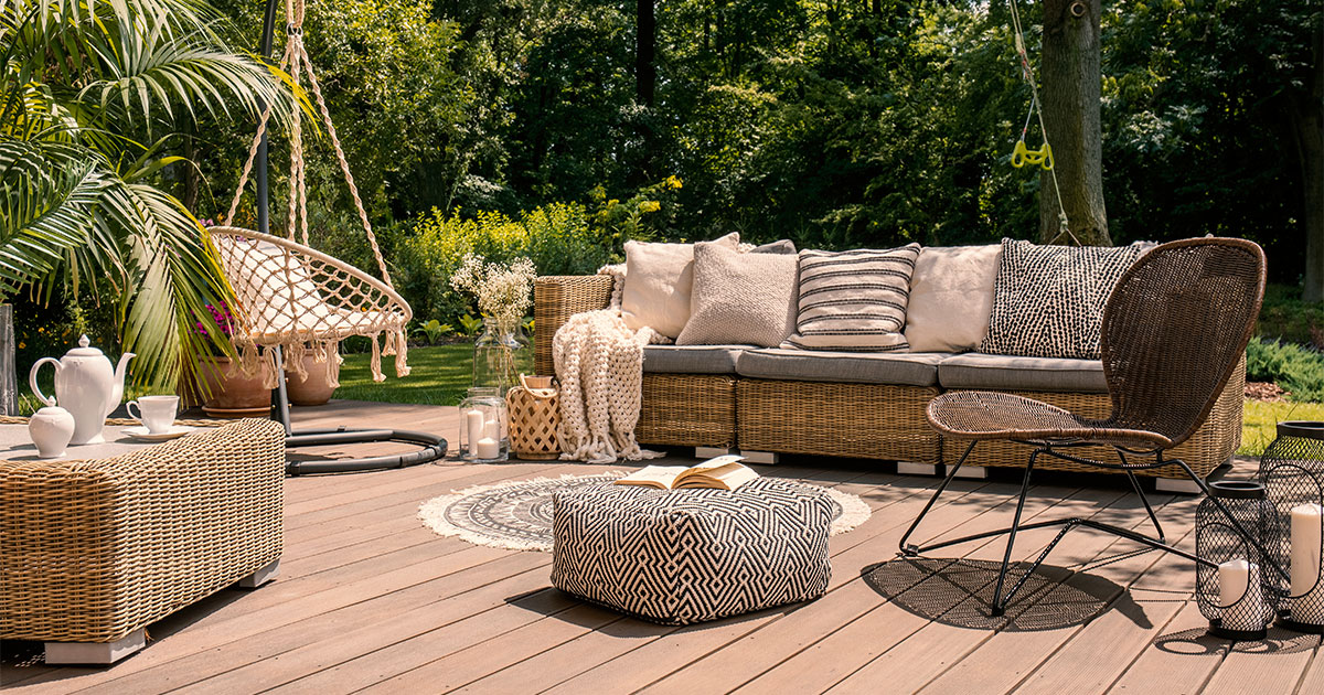 A beautiful outdoor space with a couch, a swing, and chairs on a deck