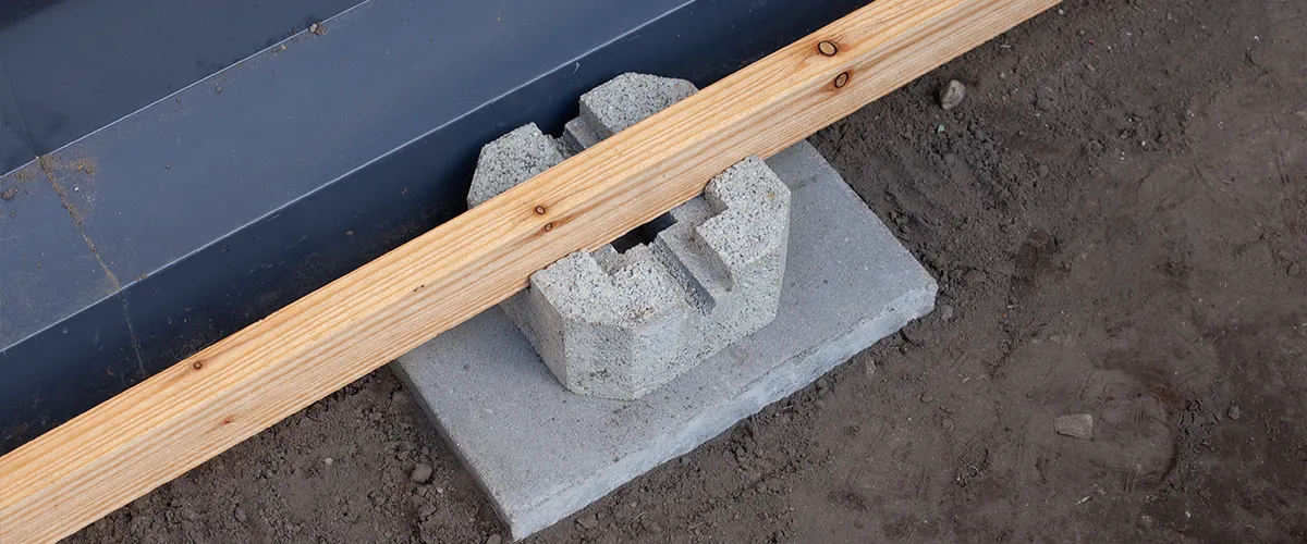 Deck footings with a concrete block and a piece of lumber