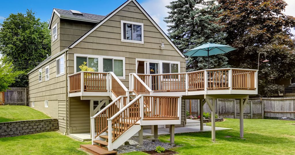 An elevated deck with two set of stairs in front of the home