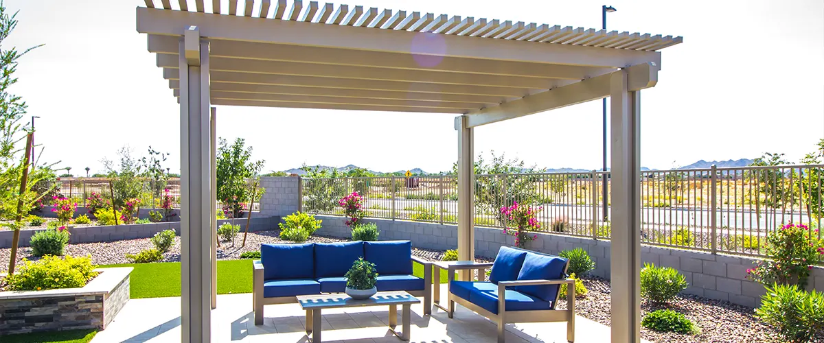 A pergola on a patio with blue chairs