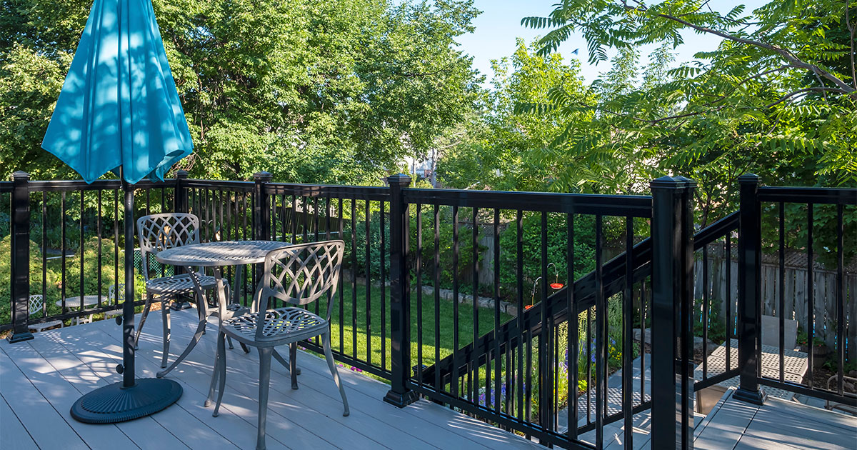 A wrought iron railing on a gray deck