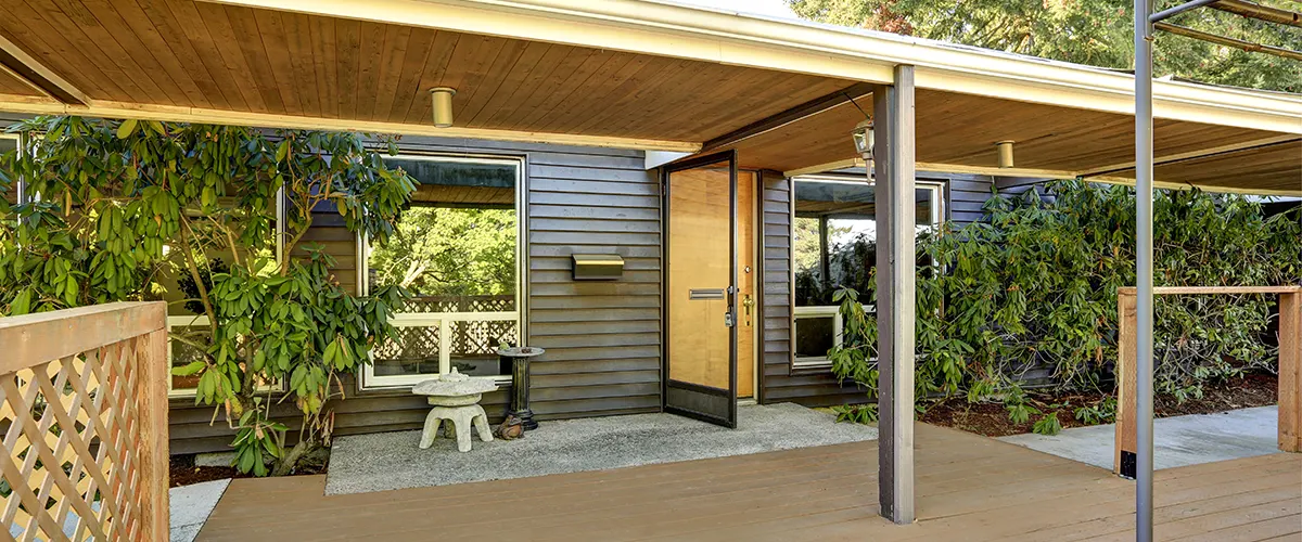 A pergola attached to a house with climbing plants