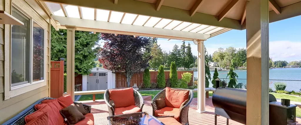 A deck pergola with red chairs