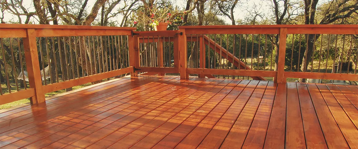 A redwood decking on a deck with wooden railing