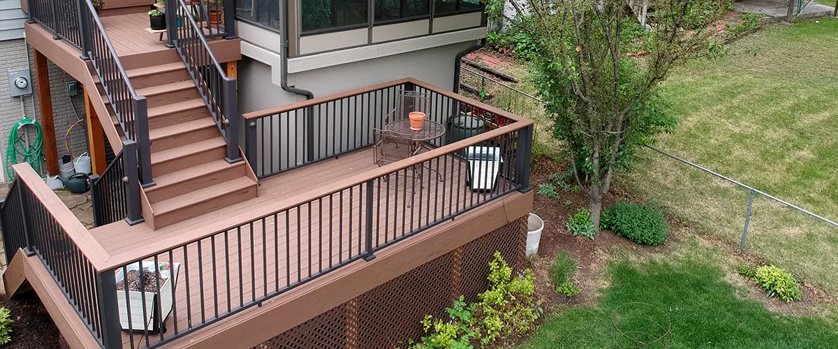 A two level deck with stairs and a metal rail