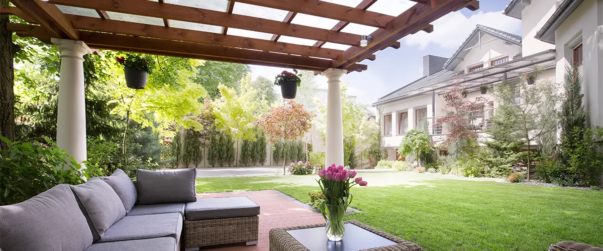 A beautiful wood pergola in the backyard of a mansion