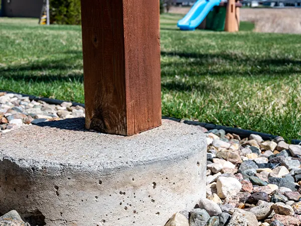 A wooden post for a deck on a concrete block