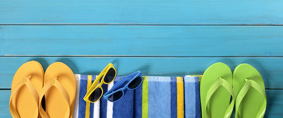 A blue deck with flip-flops and sunglasses