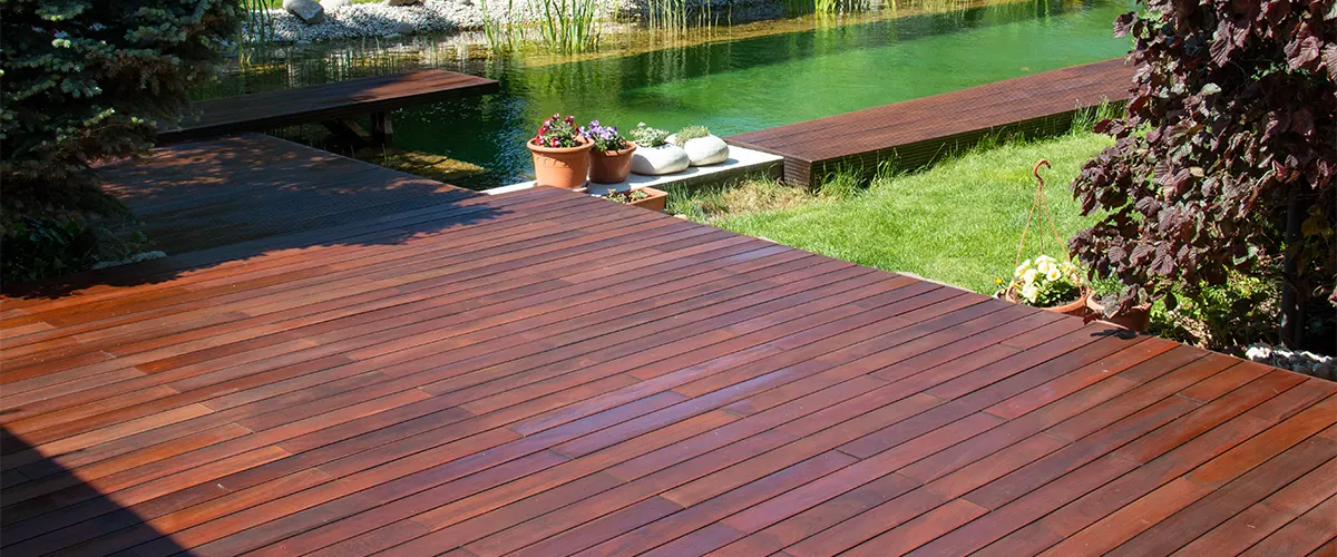 A mahogany wood deck near a pond