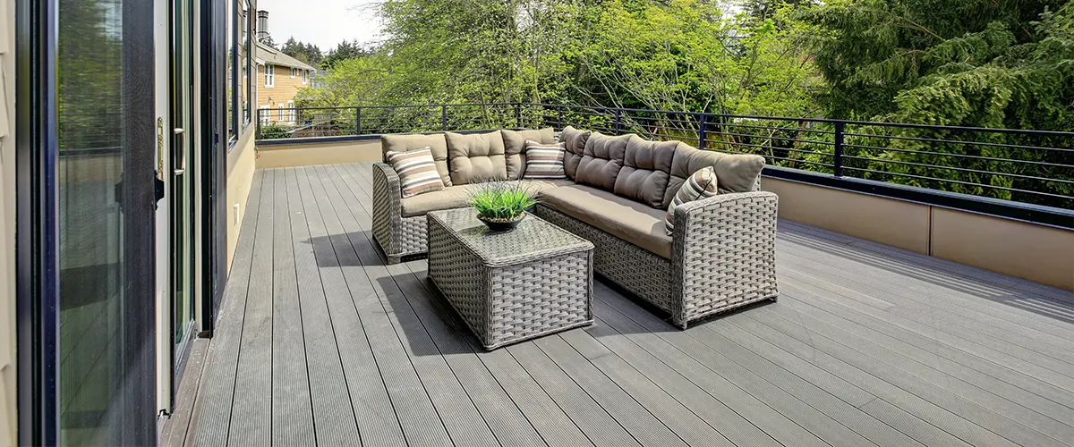 A slate gray composite deck with a L shaped couch and table