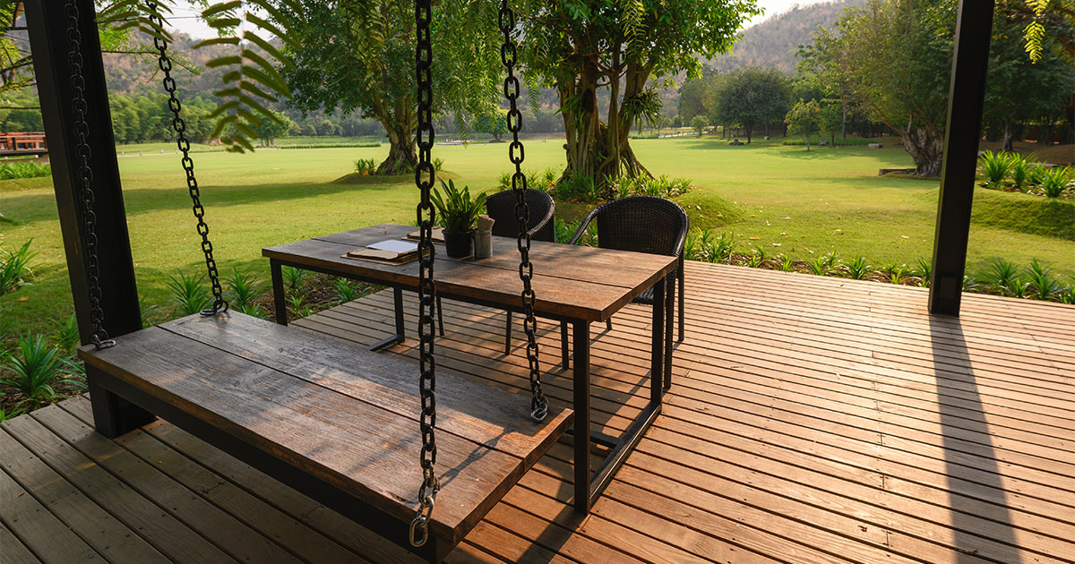 Free standing deck building cost in Bellevue of a composite decking with table and chairs on a large patch of grass