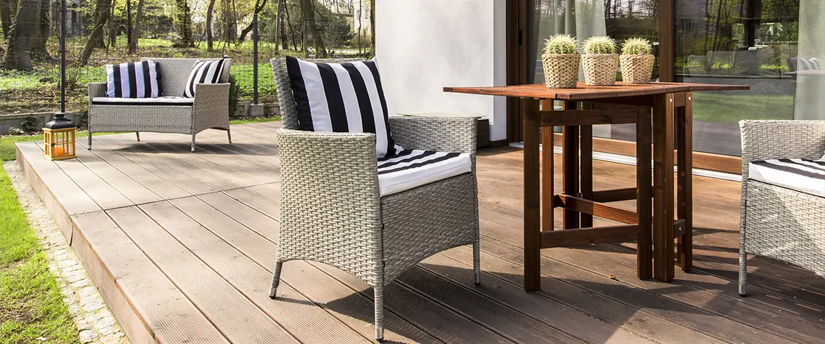 Composite boards on a ground-level deck with chairs and cactuses on a wood table