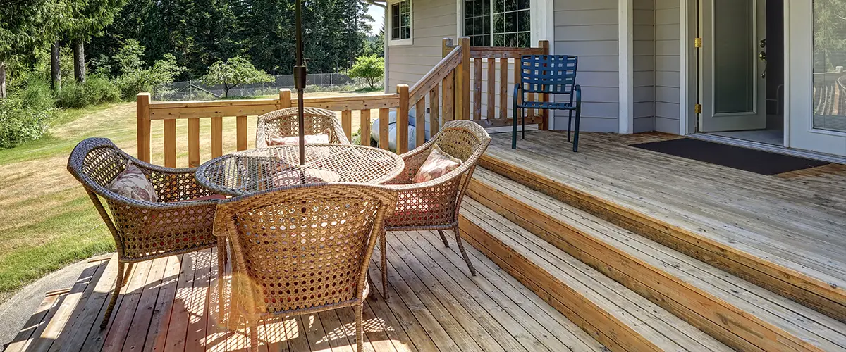 A pressure treated wood deck with a table with chairs
