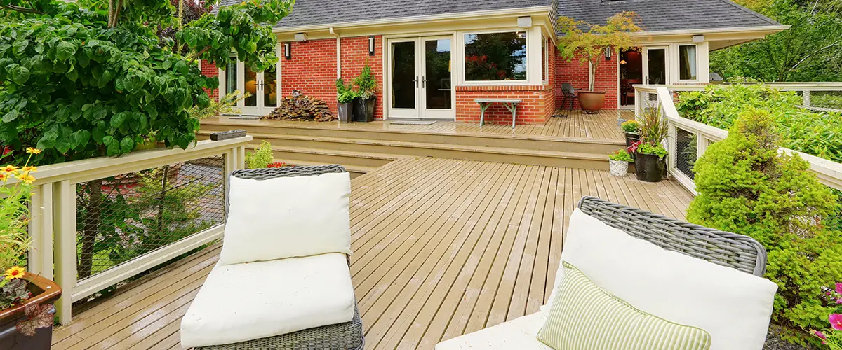 Beige composite decking with two white chairs on it