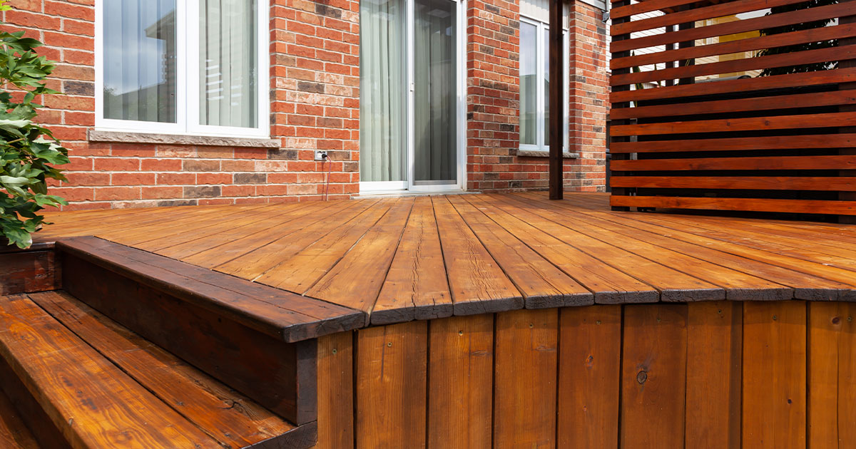 A wood deck with a brick home