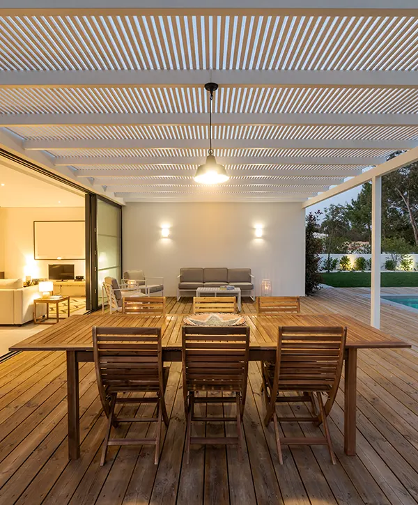 A wooden deck with a large table and wood chairs