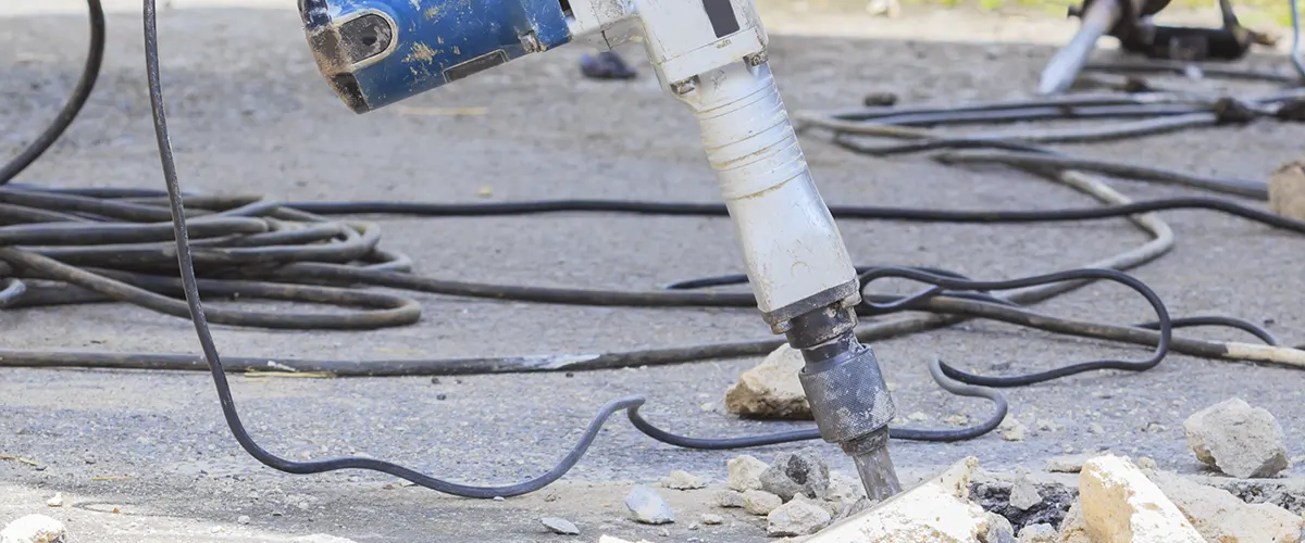 A jackhammer stuck trying to remove concrete slabs