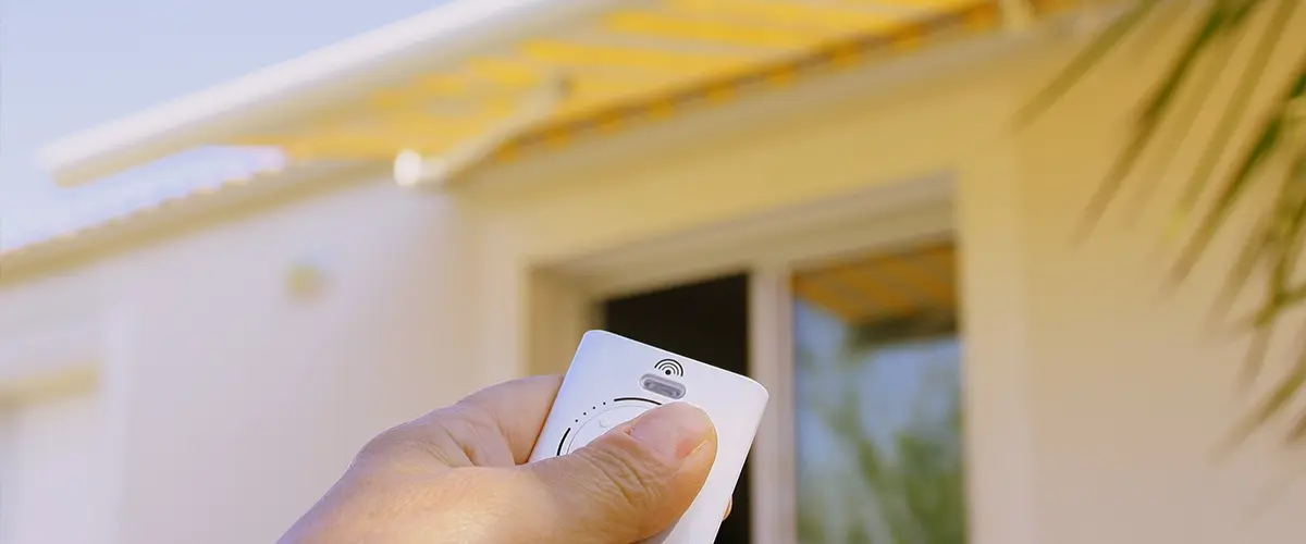 An electric awning and a man holding a remote control