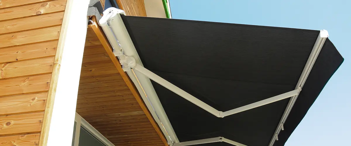 A retractable awning with dark canvas material