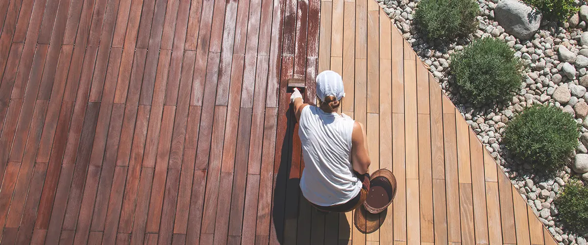 Woman staining a wood deck