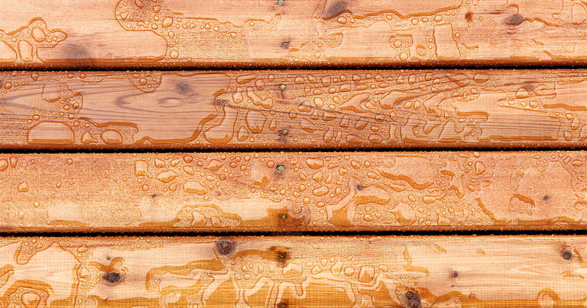 A close-up texture of cedar wood with water droplets on it