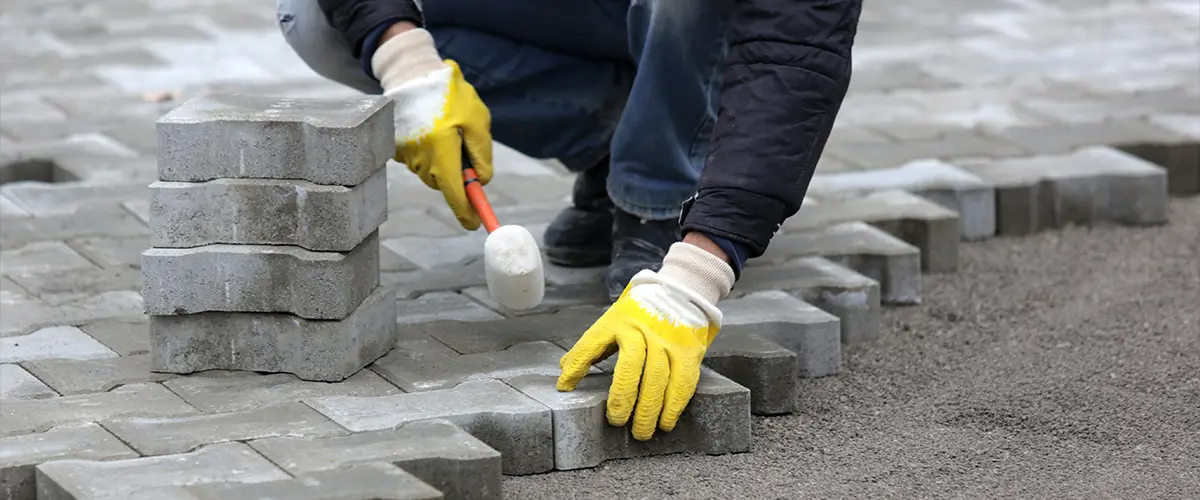 A professional installing a paver patio