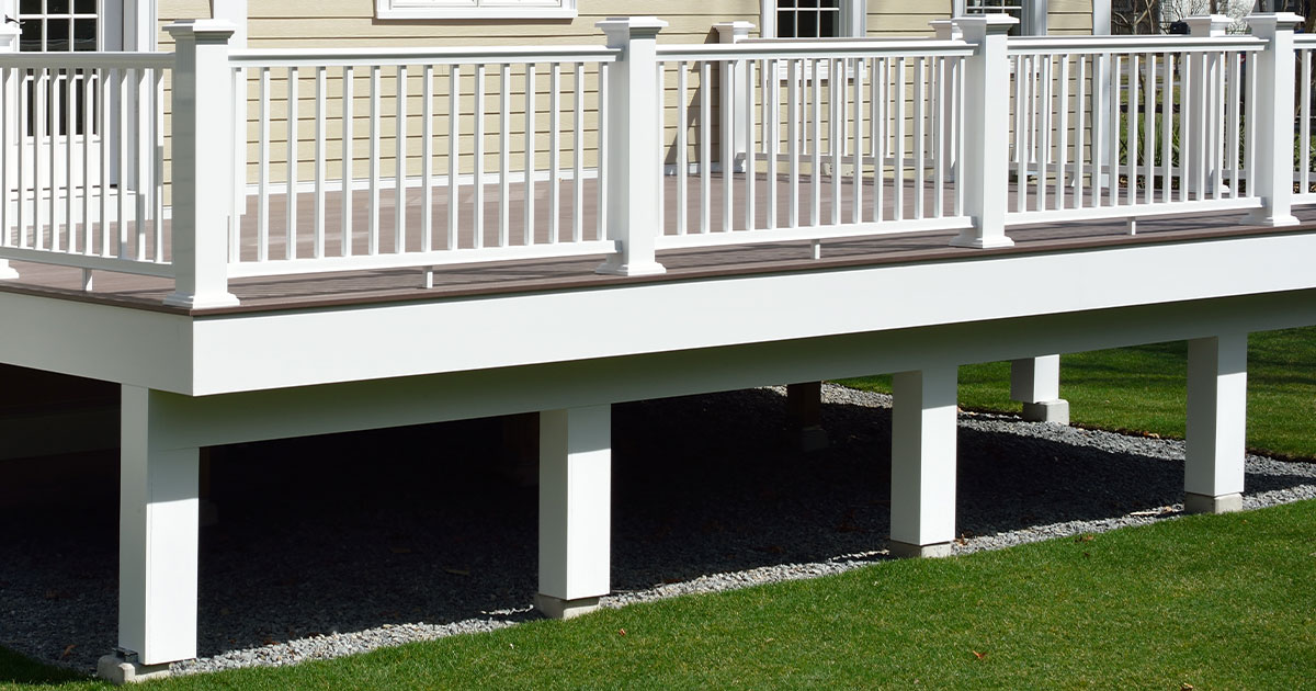 A fascia board on an elevated deck with white railing
