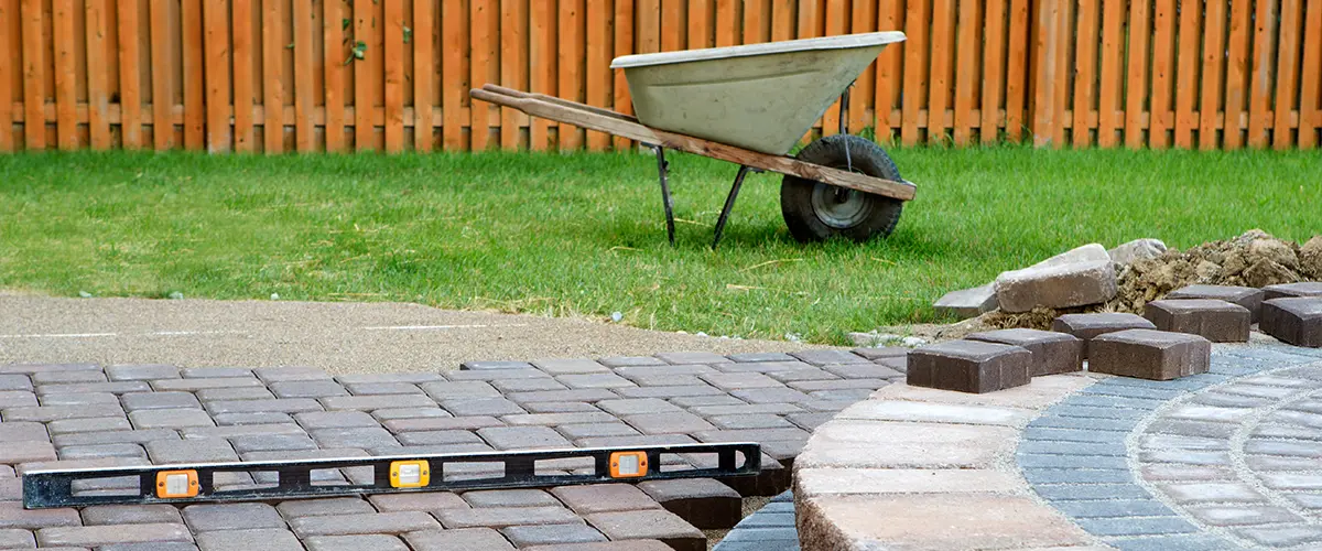 A wheelbarrow and level for a paver patio installation