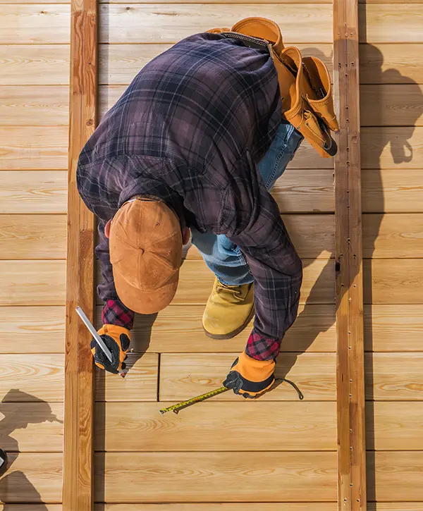 A deck builder repairing a wood deck
