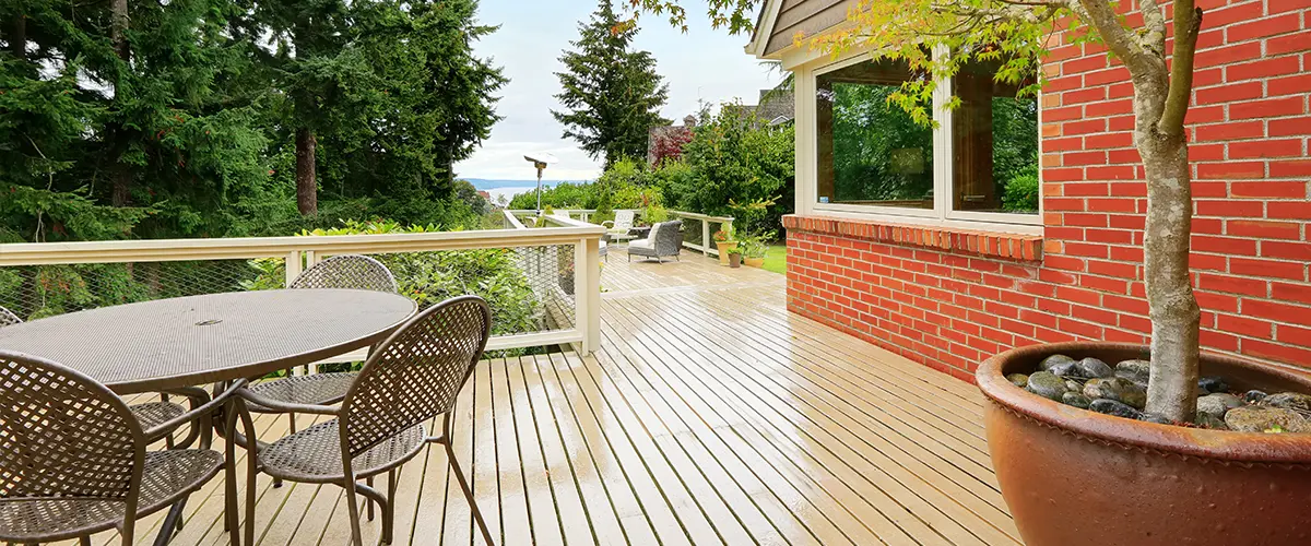 Wood decking near a brick building and outdoor furniture