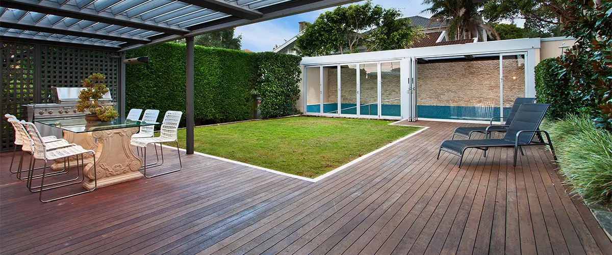 Ground level deck with wood boards and a long chair